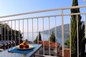 a bowl of fruit on a table on a balcony at Guest House Tomanovic in Herceg-Novi