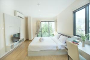 a bedroom with a white bed and a window at Park 19 Hotel in Bangkok