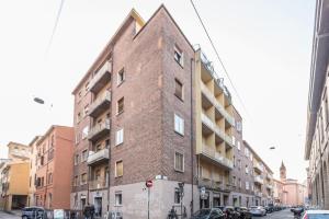 a tall brick building on a city street at Unione, Bologna by Short Holidays in Bologna