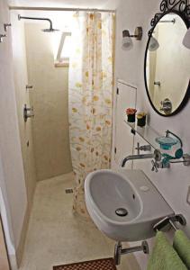 La salle de bains est pourvue d'un lavabo et d'un miroir. dans l'établissement Casetta di paese, à Matino