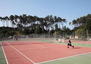 a group of people walking on a tennis court at Les fougères A81 Les villages sous les pins LEON 40550 in Léon