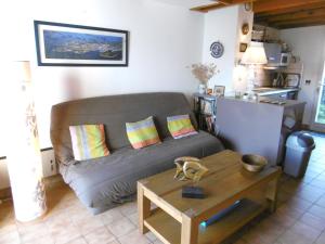 uma sala de estar com um sofá e uma mesa em Maisonnette Solenn em Sarzeau