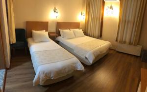 a hotel room with two beds and a chair at Ottoman's Pearl Hotel in Istanbul
