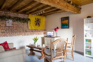 sala de estar con mesa, sillas y sofá en Gîte de La Ferme des Crins Blancs, en Hazebrouck