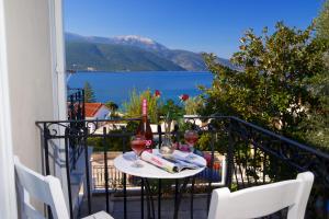 a table with two glasses of wine on a balcony at Prince Studios in Sami