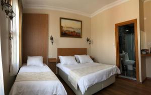 a bedroom with two beds and a bathroom at Ottoman's Pearl Hotel in Istanbul