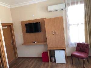 a room with a chair and a tv on a wall at Ottoman's Pearl Hotel in Istanbul