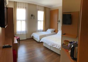 a hotel room with two beds and a flat screen tv at Ottoman's Pearl Hotel in Istanbul