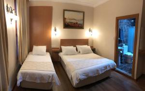 a hotel room with two beds and a mirror at Ottoman's Pearl Hotel in Istanbul