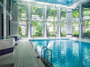 une grande piscine intérieure avec fenêtres et une grande piscine dans l'établissement VacationClub – Olymp Apartament 211, à Kołobrzeg
