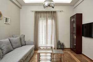 ein Wohnzimmer mit einem Sofa und einem Tisch in der Unterkunft Charming Studio Apartment in Athen