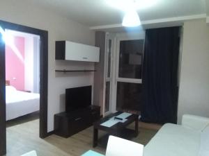 アランダ・デ・ドゥエロにあるAparthotel Ciudad de Arandaのリビングルーム(白いソファ、テレビ付)