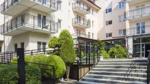 a building with stairs and bushes in front of it at VacationClub – Olymp Apartament 211 in Kołobrzeg