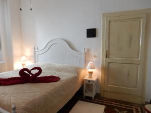 Un dormitorio con una cama con dos cisnes rojos. en B&B Eleonora D'Arborea, Centro Storico en Posada