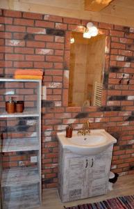 a bathroom with a sink and a brick wall at Domki Górskie Zacisze in Koniaków