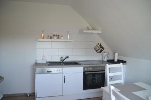 una cucina bianca con lavandino e piano cottura di Ferienwohnung Grensemann a Schneverdingen