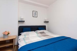 Schlafzimmer mit einem blauen Bett und einem Tisch in der Unterkunft Apartman Lux in Daruvar