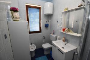 ein Badezimmer mit einer weißen Toilette und einem Waschbecken in der Unterkunft Apartment Adriana in Rovinj