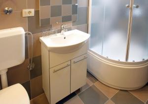 a bathroom with a sink and a shower and a toilet at Apartments Infinitas in Trogir +38 photos