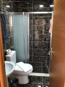 a black tiled bathroom with a toilet and a sink at Ottoman's Pearl Hotel in Istanbul