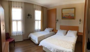 a hotel room with two beds and a chair at Ottoman's Pearl Hotel in Istanbul