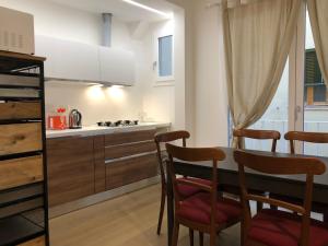 フィレンツェにあるSan Frediano Apartmentのキッチン(テーブル、椅子、コンロ付)