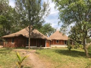 a house with a thatched roof and a yard at Bintang Bolong Lodge in Bintang