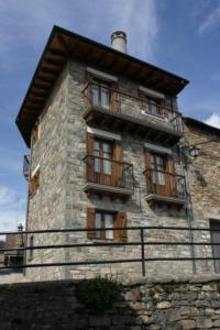 Edificio de piedra antiguo con ventanas y balcón en Casa Magdalena Autural, en Siresa