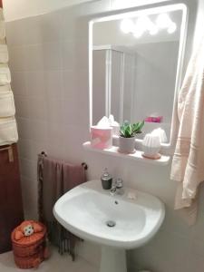 a bathroom with a white sink and a mirror at Elison-on the lake B&B in Sauris