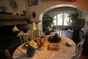 una mesa de comedor con jarrones de flores. en Mas Les Micocouliers en Saint-Christol-lès-Alès