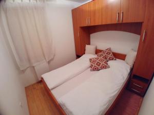 a small bedroom with two beds and wooden cabinets at Apartment Panorama 1 in Vlasic