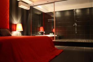 a bedroom with a shower and a bed with a red blanket at São Gonçalo - Alojamento in Azeitao