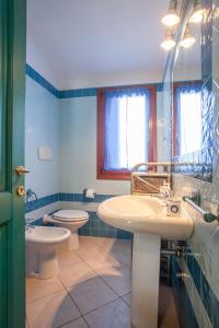 uma casa de banho com 2 WC, um lavatório e um WC. em Maestrale Flat - Klodge em Olbia