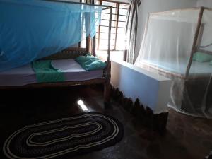 Zimmer mit 2 Etagenbetten und einem Teppich in der Unterkunft Mango Lodge Kenya in Kisimachande