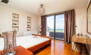 a bedroom with a bed and a view of the ocean at GOLD DREAM HOME in Agios Onoufrios