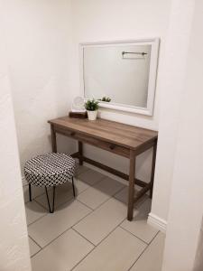 ein Badezimmer mit einem Tisch, einem Spiegel und einem Stuhl in der Unterkunft Downtown Bungalow- 2 bedroom in Cedar City