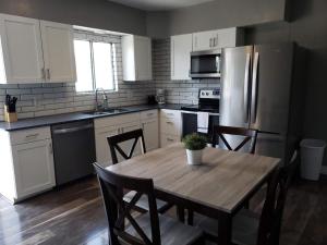 eine Küche mit einem Tisch mit Stühlen und einem Kühlschrank in der Unterkunft Downtown Bungalow- 2 bedroom in Cedar City