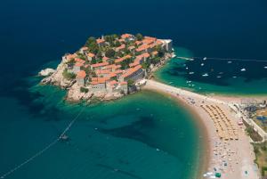 an island in the water with a house on it at Apartmani More in Sveti Stefan