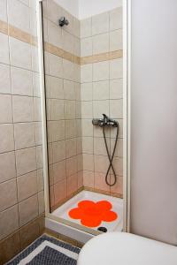 bagno con doccia e servizi igienici con coperchio rosso di HOTEL STOUPA a Stoupa