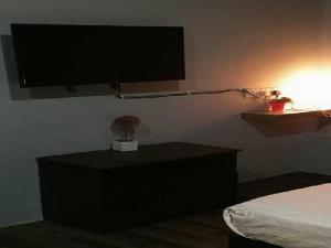 a bedroom with a tv on the wall and a bed at Lucky Hotel in Sungai Petani
