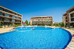 a large pool with a fountain in front of some buildings at Waterpark Fort Apartments in Sunny Beach