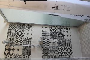 a bathroom with black and white tiles on the wall at Sa Domu Beccia B&B in Uras