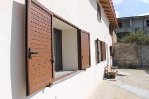 - une fenêtre sur un bâtiment avec volets en bois dans l'établissement Sa Domu Beccia B&B, à Uras