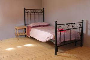 una camera con letto nero e pavimento in legno di Sa Domu Beccia B&B a Uras