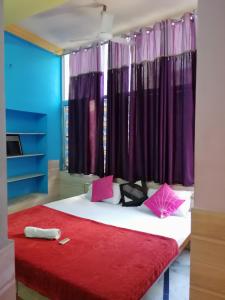 1 dormitorio con 1 cama grande y cortinas moradas en Royal Heritage Guest House en Jodhpur