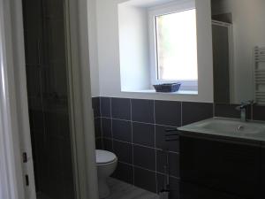 bagno con servizi igienici, lavandino e finestra di Gîte du Moulin du Vey a Clécy