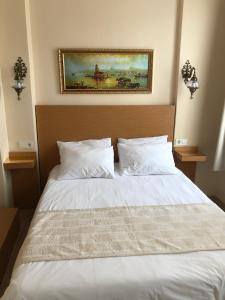 a bedroom with a white bed with a picture on the wall at Ottoman's Pearl Hotel in Istanbul