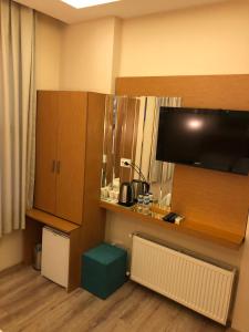 a hotel room with a desk and a tv and a room at Ottoman's Pearl Hotel in Istanbul