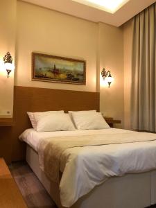 a bedroom with a bed with a painting on the wall at Ottoman's Pearl Hotel in Istanbul