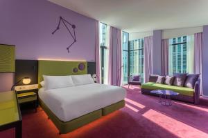 a bedroom with a large bed and a couch at Room Mate Bruno, Rotterdam in Rotterdam